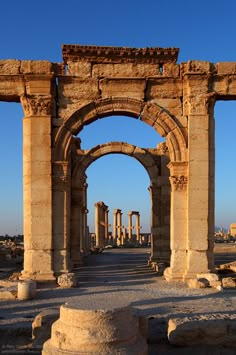 an arch in the middle of a stone structure with columns and arches on either side