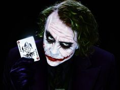 the joker holding a playing card in his right hand