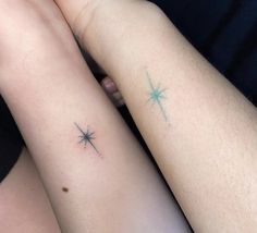 two people with matching tattoos on their arms, one is holding the other's arm