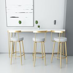 three stools and a table with a plant on it in front of a white wall