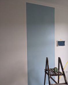 a ladder leaning against a wall painted in blue and white