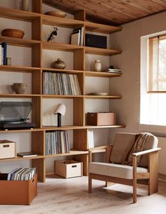 a wooden book shelf filled with lots of books and vinyl record's on top of it