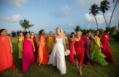 a group of women standing next to each other on top of a lush green field