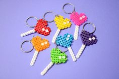 six lego keychains made to look like candy lollipops on a purple background