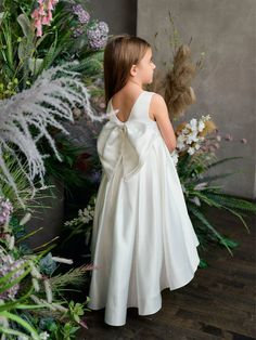 Introducing the Teter Warm Couture Flower Girl Satin Tea Length Dress, a charming and elegant choice for special occasions. This exquisite dress features a stunning off-white color that is both timeless and beautiful. The round neckline and sleeveless design offer a classic and sophisticated look, while the zip closure ensures a secure and comfortable fit. The dress is crafted from high-quality satin material, both in the bodice and skirt, for a luxurious feel and graceful drape. Adding a touch Satin Tea Length Dress, Baby Christening Outfit, Nylon Skirt, Flower Girl Outfit, Off White Dress, Girls Communion Dresses, Net Skirt, Tea Length Dress, Skirt Lining