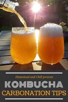 two glasses of kombucha are sitting on a table with the sun behind them