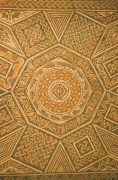 an intricate design on the side of a building in india, with gold and brown colors