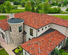 an aerial view of a house with red tile roofs