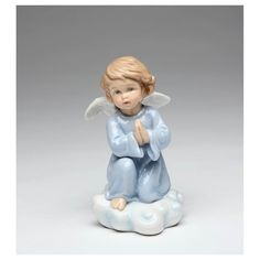 an angel figurine sitting on top of a cloud with his hands folded in prayer