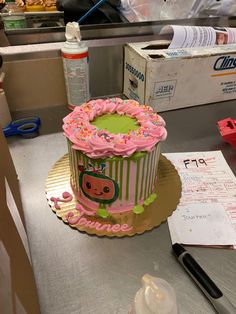 a cake with pink frosting and sprinkles sitting on top of a counter