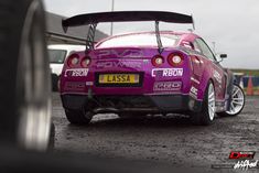 the back end of a purple car parked in a parking lot