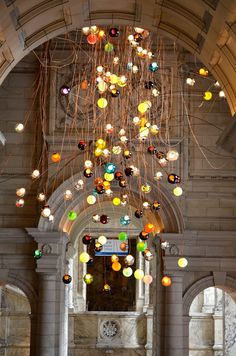 a large chandelier hanging from the ceiling in an old building with columns and arches