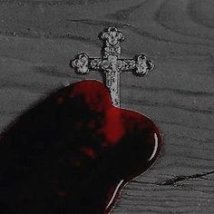 a red heart with a cross on it sitting in front of a black and white background