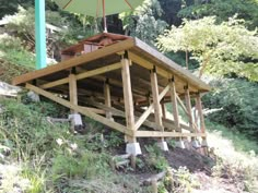 a wooden structure on the side of a hill under an umbrella