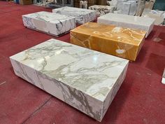 marble boxes sitting on top of a red floor in a room filled with other items