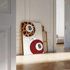 a number eight sign sitting on top of a wooden floor next to a white wall