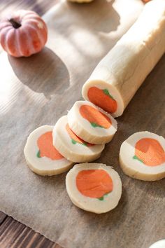 several pieces of food sitting on top of a piece of paper next to some pumpkins