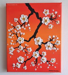 an orange and red painting with white flowers on the branch, against a white wall