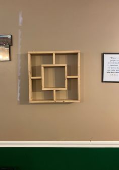 a wooden shelf sitting on top of a green wall