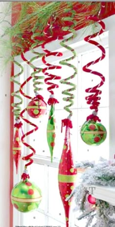 christmas decorations hanging from the ceiling in front of a window