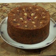 a chocolate cake with nuts on top sitting on a plate