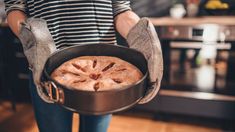 a person holding a pan with some food in it