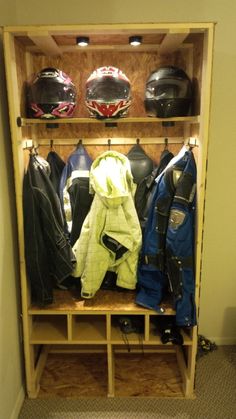 a wooden shelf filled with helmets and jackets