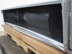 a microwave oven sitting on top of a wooden pallet next to a white wall