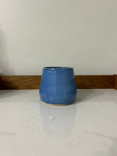 a blue cup sitting on top of a white counter