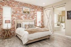 a bedroom with brick walls and white bedding