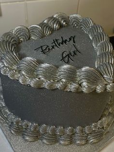 a birthday cake that has been decorated with silver icing and writing on the top