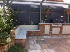 an outdoor kitchen and grill area in a backyard