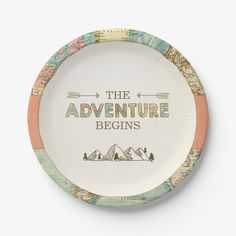 a paper plate with the words the adventure begins printed on it and mountains in the background