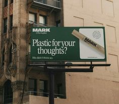 a sign that says plastic for your thoughts on the side of a building in front of a tall brick building