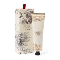 a tube of hand and foot lotion in front of a white box with flowers on it