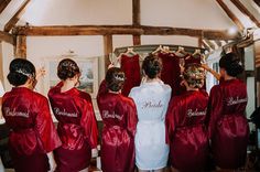 a group of women in red robes standing next to each other with their backs turned