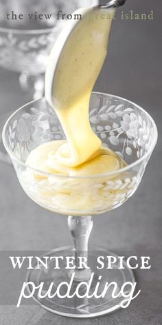 a glass bowl filled with yellow liquid and sauce being poured into the bowl to make a dessert