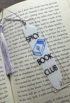 a bookmark with the words spicy book club and a tassel hanging from it