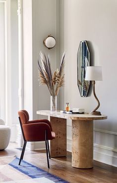 a room with a table, chair and mirror on the wall next to each other