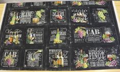 a table topped with lots of chalkboard covered in wine bottles and glasses on top of it