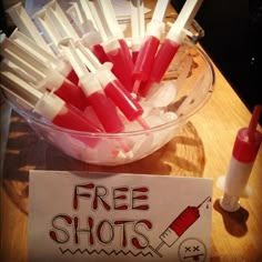 a bowl full of toothpicks and a sign that says free shots on it