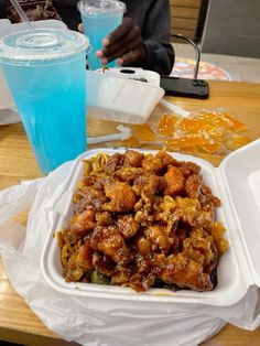 there is a plate of food on the table next to a blue cup and plastic container