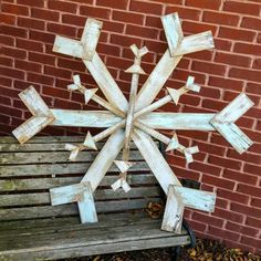 a wooden snowflake sitting on top of a bench next to a brick wall