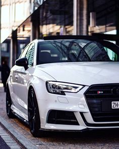 a white car parked in front of a building