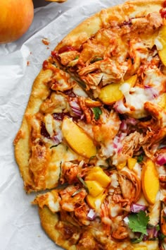 a pizza topped with chicken, peaches and onions