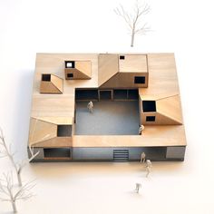 a model of a house with people standing around it