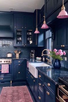 a kitchen with blue cabinets, pink rug and gold accents on the countertops is shown