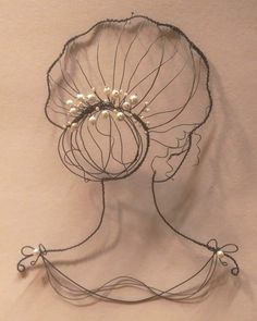 a wire sculpture with pearls on it's head