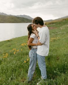 a man and woman standing next to each other in the grass