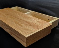 a wooden box sitting on top of a black surface